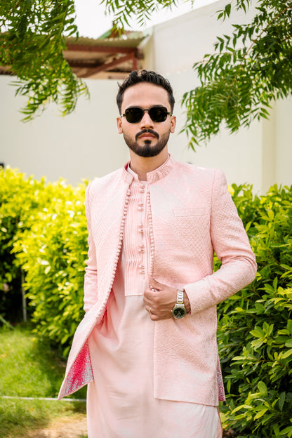Pastel pink 3-piece prince coat set with textured sequence embroidery and pearl-button detailing on the front. Layered over a pleated pink kurta and matching straight trousers